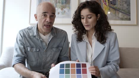 Confident-young-woman-with-mature-colleague-showing-color-palette